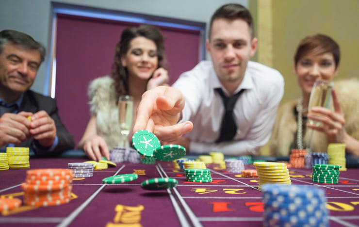 A player tossing chips onto a roulette table.