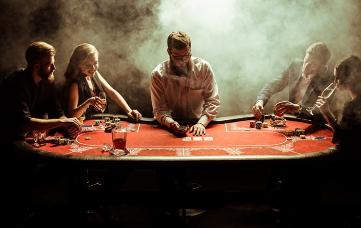 A poker table full with gamblers.