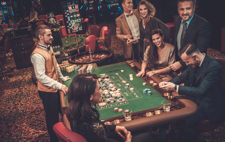 Players sitting around a roulette table.