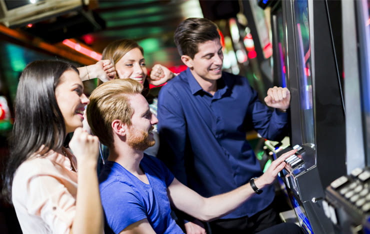 A group of people playing slots.